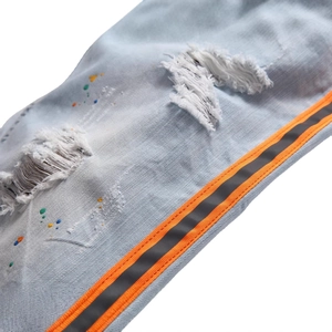 Jean homme bleu clair avec taches de peinture et bandes latérales orange sport