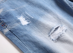 Close-up of distressed denim shorts showing torn details and light blue cotton texture