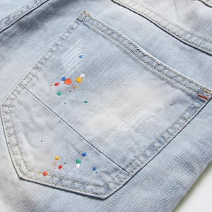 Short en jean bleu clair streetwear avec éclaboussures de peinture et détails usés