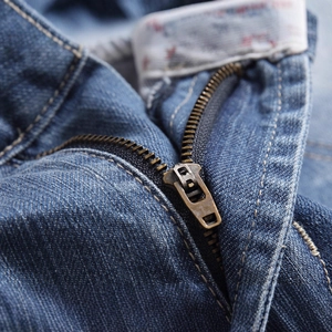 Gros plan détaillé d'un short en jean d'été avec fermeture éclair en métal vintage et denim bleu