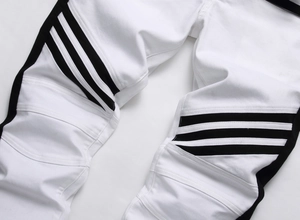Detail view of motorcycle-style ribbed panels and parallel black stripes on white trousers