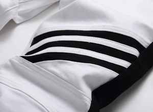 Detailed macro view of white twill denim with black side patchwork and triple tape stripes
