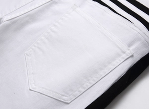 Detail of white denim pants showing hexagonal back pocket and three black side stripes