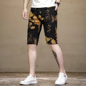 Détail du short noir ajusté pour homme avec éclaboussures d'encre dorées et imprimé lettre B