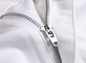 Detailed macro view of high-quality silver metal zipper on white twill denim jeans