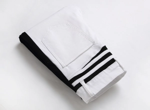 Detail view of monochrome patchwork jeans with black side panels and sporty stripes