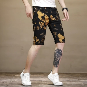 Détail d'un short en jean coupe ajustée avec imprimé camouflage éclaboussé noir et or