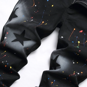 Men's slim black denim jeans with colorful paint splatter and star print pattern