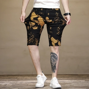 Détail du short noir pour homme avec motif abstrait orange et imprimé lettre B stylisé