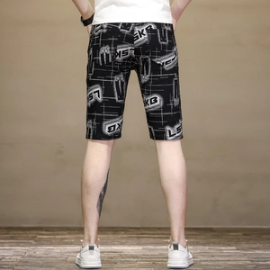 Detail view of black summer shorts featuring white letter print and grid line patterns