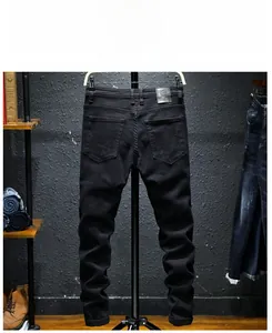Slim fit black denim pants back view with embossed grey leather patch and classic pockets