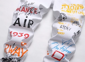 Gros plan sur les imprimés graffiti colorés AIR et 1939 sur un pantalon blanc