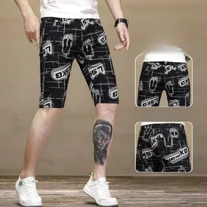 Macro detail of men's slim fit black shorts with white grid patterns and letter prints