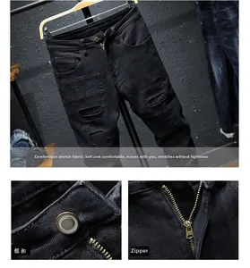 Detail of slim-fit black distressed denim showing stretch fabric, metal button and zipper