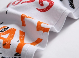Gros plan d'une impression graphique rouge et orange sur un denim blanc extensible