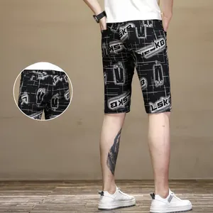 Detail view of slim fit black shorts for men with trendy white letter printing pattern