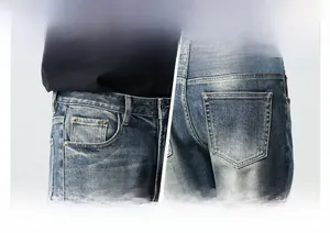 Detail view of denim jeans featuring blue leather patch and coin pocket design