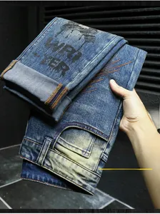 Detail of vintage blue washed denim with black street art printing and yellow stitching