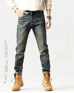 Detail shot of men's slim straight jeans with vintage light blue washed distressed fabric