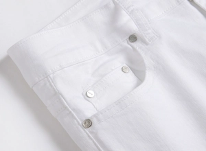 Detailed close-up of white denim waist with silver rivets and fine stitching on pockets