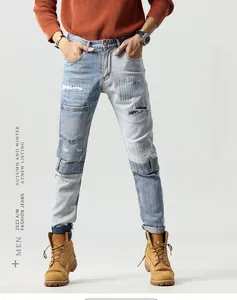 Detailed shot of light blue patchwork jeans featuring distressed holes and repair stitching