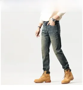Detailed side view of washed vintage blue slim fit men's jeans with whisker texture