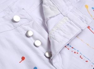Detail einer weißen Slim-Fit-Jeans mit vier Silberknöpfen und bunten Farbspritzern