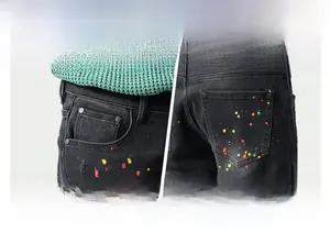 Detailed close-up of retro black-gray jeans featuring artistic multicolor paint splatter accents