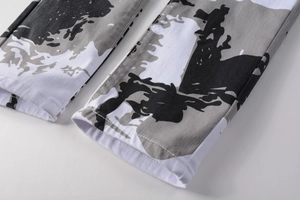 Détail de l'ourlet du jean camouflage blanc avec tissu sergé et coutures de précision