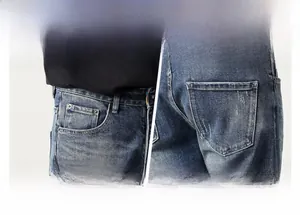 Detail view of denim jeans featuring front pockets and back pockets with orange stitching