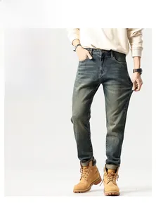 Detail of vintage washed slim fit straight leg denim jeans with classic work boots