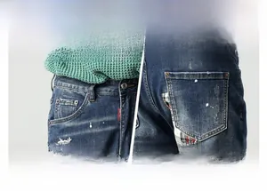 Details von weißen Blumenstickereien und buntem Karo-Patchwork auf gewaschenen Blue Jeans