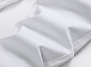 Detailed macro view of white twill cotton fabric texture and precise stitching on denim