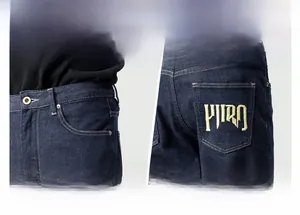 Détail du jean bleu foncé montrant les coutures de taille et la broderie dorée