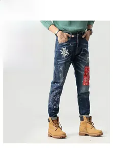 Detail einer schmal geschnittenen Jeans mit Patchwork, Paisleymustern und Blumenstickerei