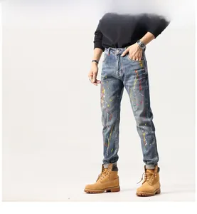 Vue détaillée du jean bleu slim avec des éclaboussures de peinture colorées et usées