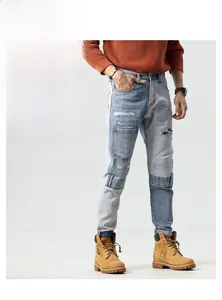 Detail of color-block patchwork denim jeans with distressed holes and embroidery