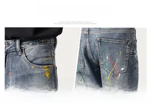 Vue détaillée du jean biker bleu ajusté avec effets d'éclaboussures de peinture colorées