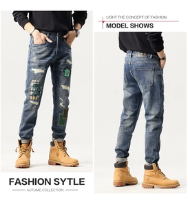 Detail of vintage washed jeans with patchwork, embroidery, and distressed denim patches