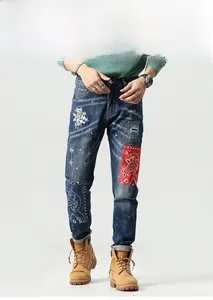 Detailansicht der Slim-Jeans mit Blumenstickerei, Flicken und markanten Destroyed-Effekten