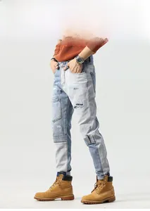 Detail of color-block patchwork denim jeans with distressed holes and cargo stitching