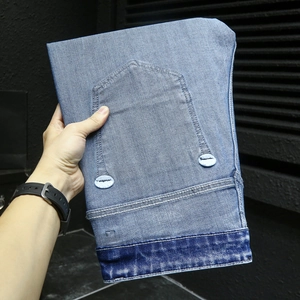Détail du jean délavé bleu clair avec ourlet contrasté et coutures sur la poche arrière