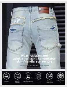 Detailed view of men's jeans with leather brand patch and stylish frayed pocket details