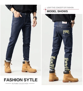Détail d'un jean bleu droit avec imprimés tête de mort et lettres vintage sur le dos