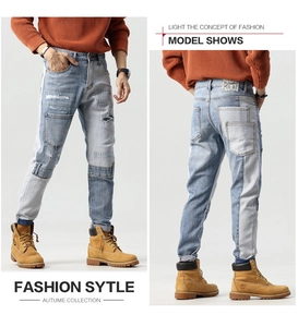 Detail shot of slim fit patchwork denim jeans featuring distressed holes and contrast stitching