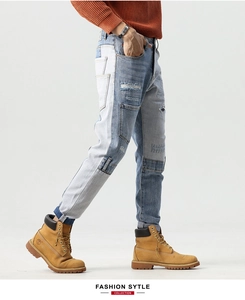 Detail of color-block patchwork and distressed ripped texture on high-street denim jeans