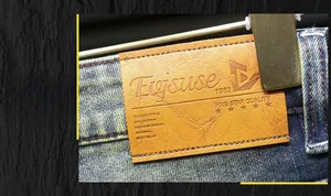 Detailed macro view of the brown leather waist label on blue washed denim jeans