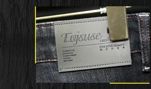 Vue macro détaillée de l'écusson en cuir gris sur un jean noir de haute qualité
