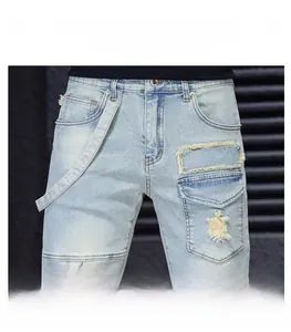 Detail of light blue washed jeans with LSKB patch embroidery and distressed hole effects