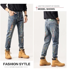 Détail de jean bleu slim pour homme avec éclaboussures de peinture multicolore et délavé